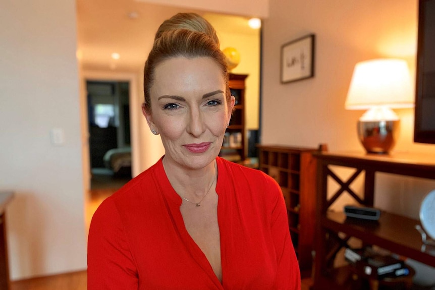 Cervical cancer survivor Jannene McLean smiles as she sits in a lounge room in Brisbane.