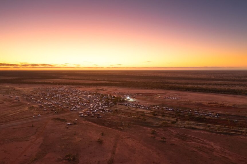 An aerial view of a small outback town in the middle of desert at sunset