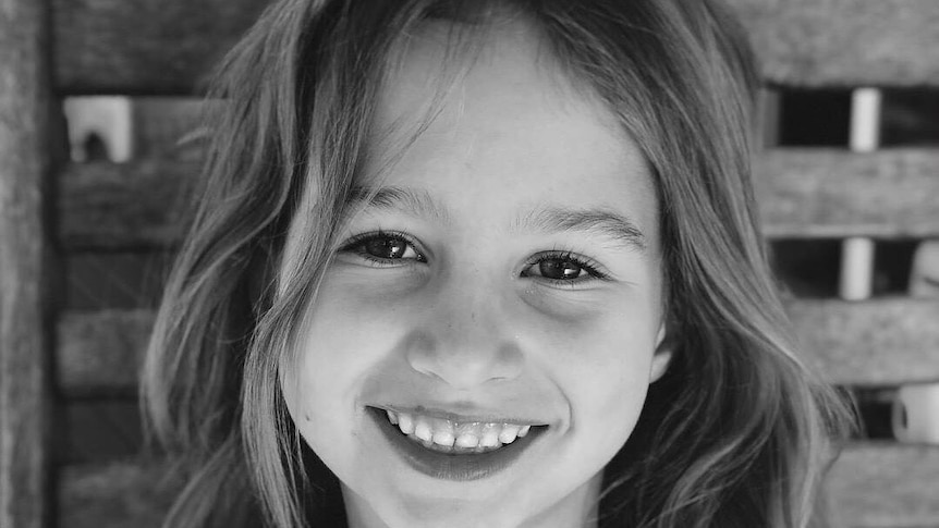 Smiling black and white photo of six-year-old Indie Armstrong.