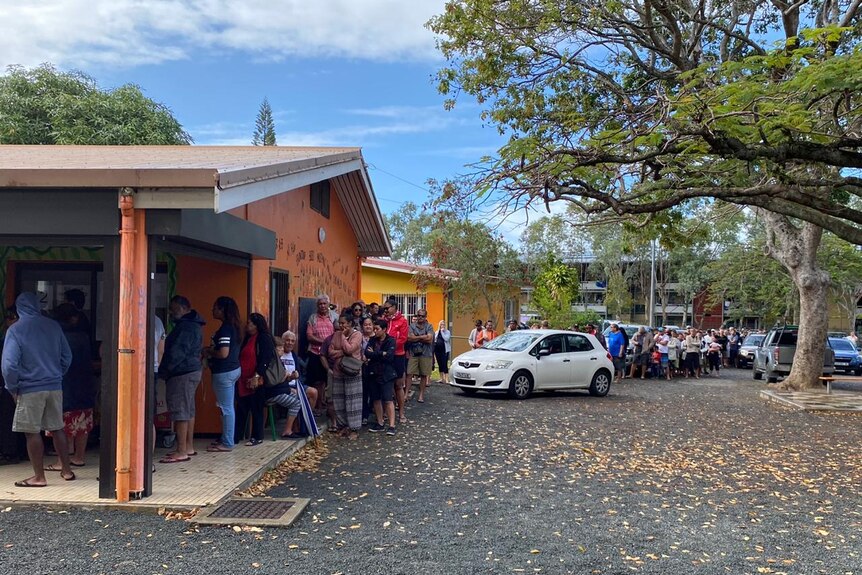 Voters queuing up in lines wrapping around local voting centres and cars.