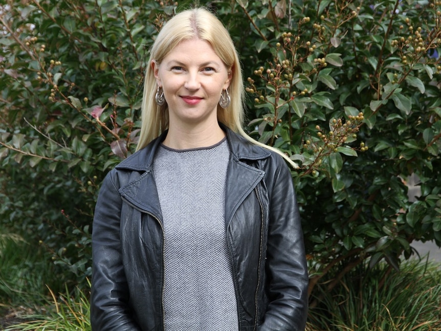 Crime writer Sarah Bailey standing in front of a bush.