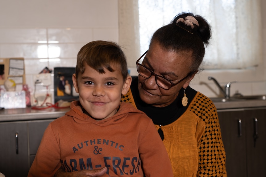 Gwen Newman cuddles her grandson in the kitchen.