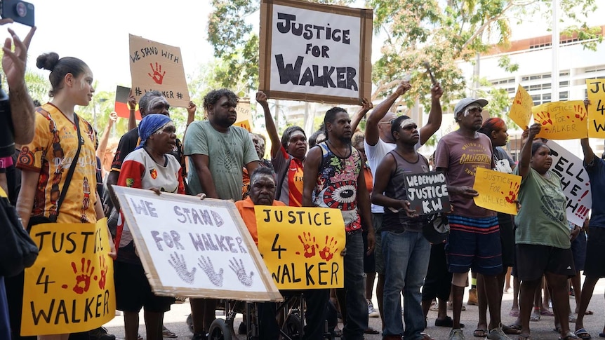 Protesters hold 'Justice for Walker' placards at a protest in Darwin's CBD.