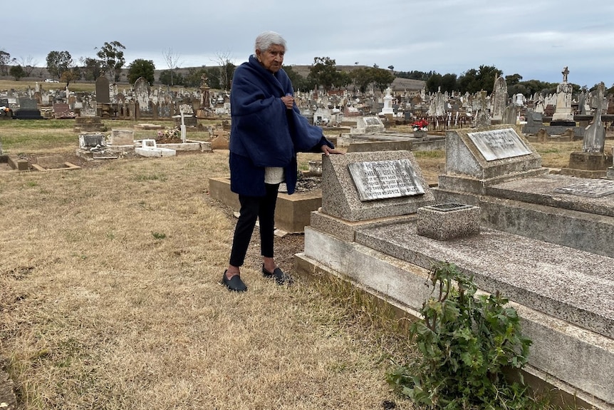 Aunty Joyce Williams next to a headstone