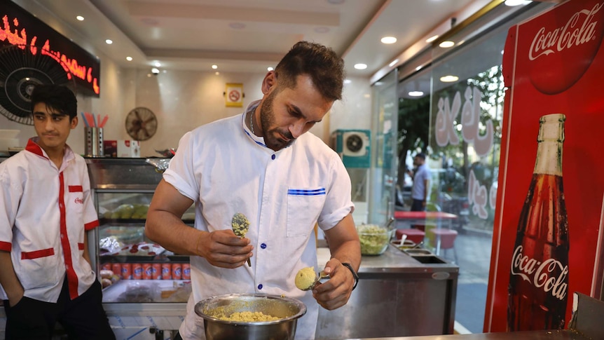 An Iranian man makes falafel at a fast food restaurant.