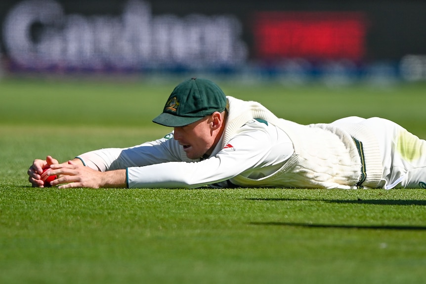 Marnus Labuschagne lies on the ground with the ball in front of him