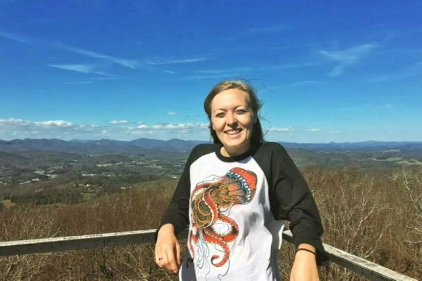 A woman stands on a lookout.