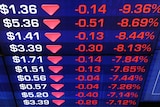 A share price display shows stocks falling on the Australian Stock Exchange (ASX) in Sydney