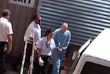 Steven Graham Peet leaves court surrounded by guards.