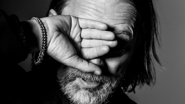 black and white portrait of Thom Yorke holding his right hand up over his face