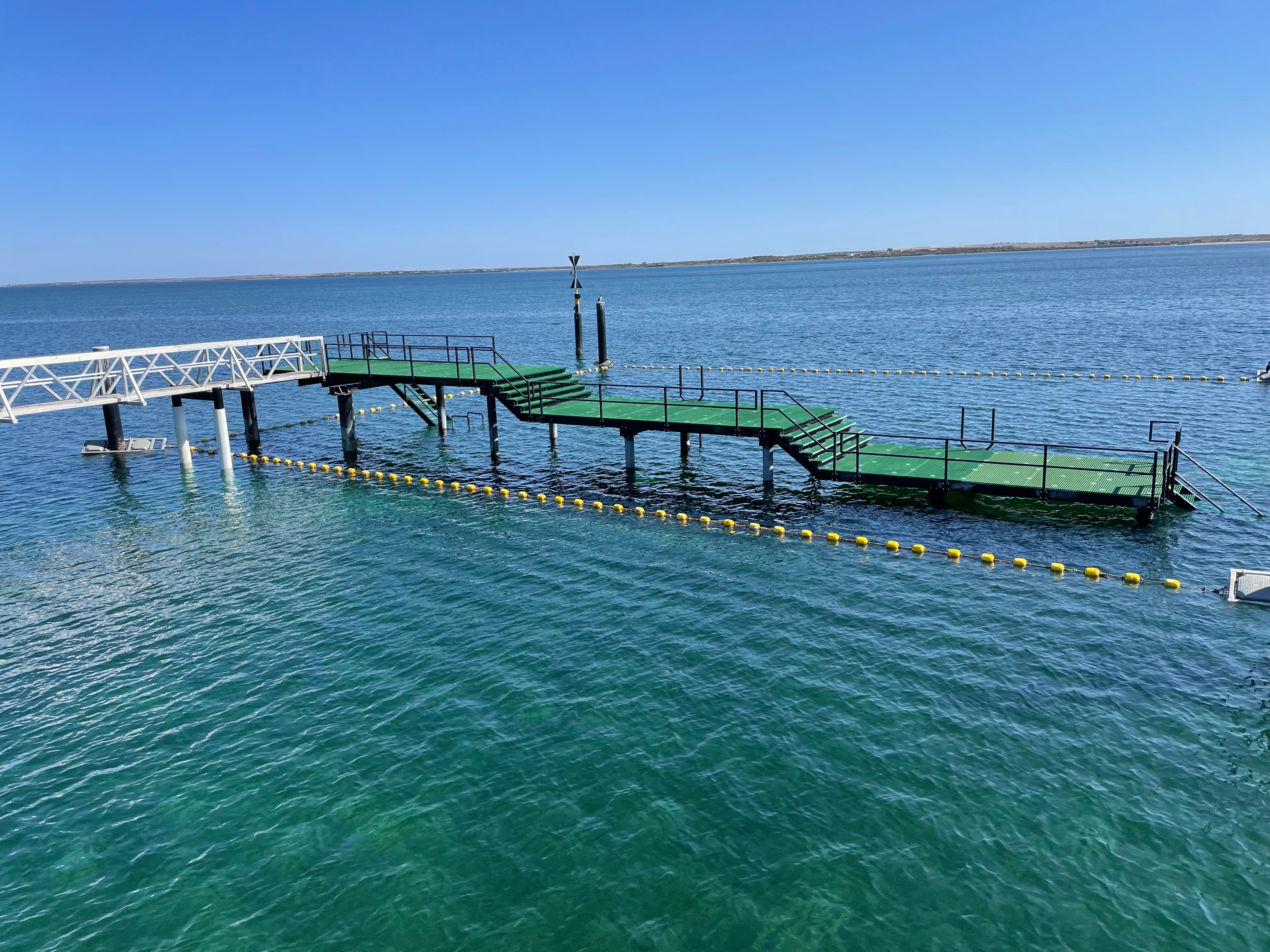 Aerial view of ceduna's ocean swimming pool with green platform connected to jetty