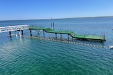 Aerial view of ceduna's ocean swimming pool with green platform connected to jetty