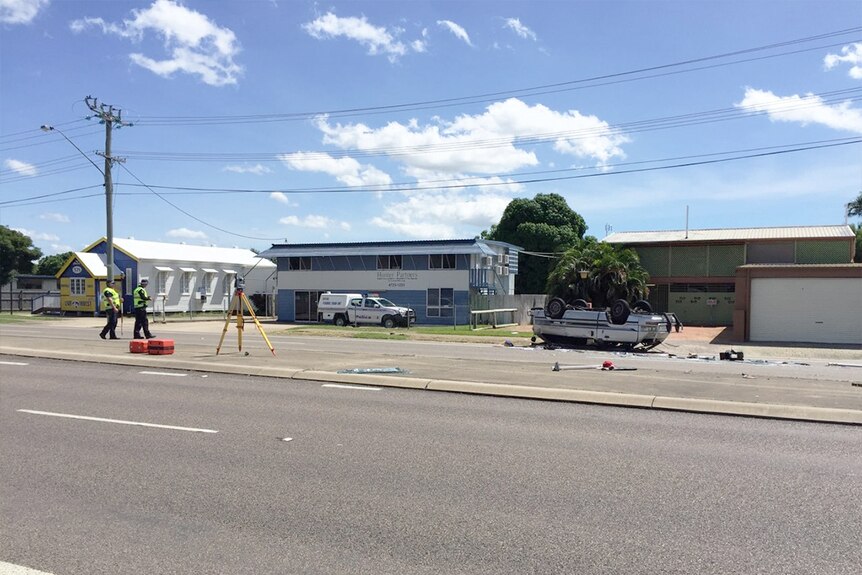 Police at scene of the crash, the van rolled over in the background.