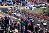 V8 supercars speed past fans on Mount Panorama.