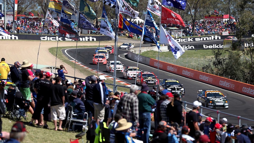 V8 super cars speed past fans on Mount Panorama.
