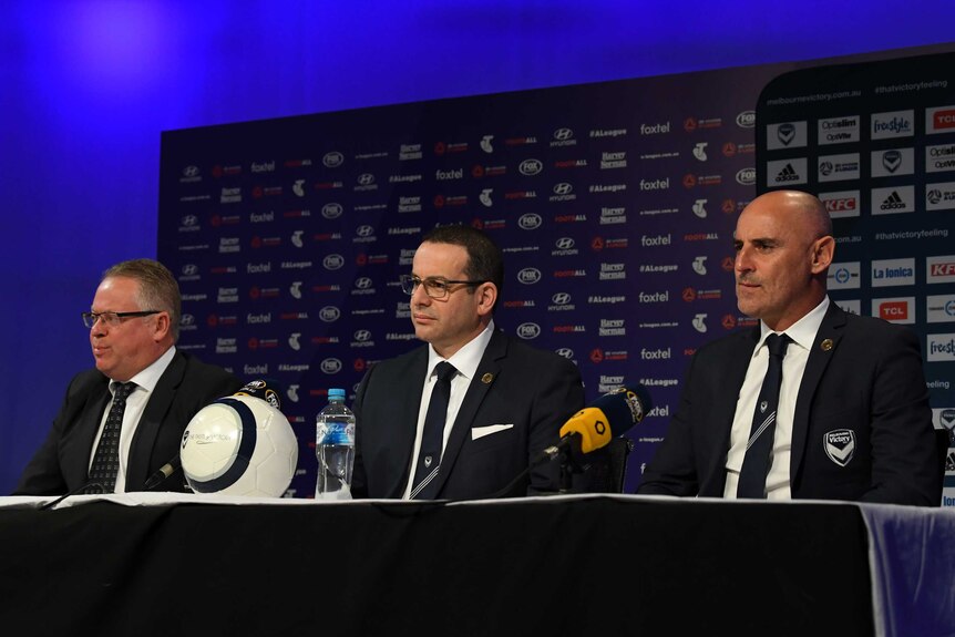 Greg O'Rourke, Anthony Di Pietro and Kevin Muscat sit at a table with a ball and microphones.
