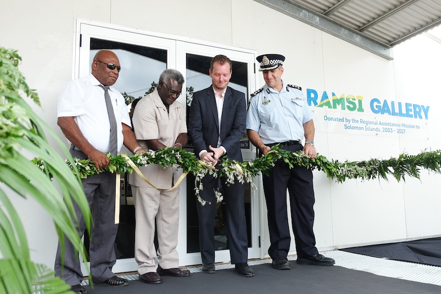 A man cutting a ribbon.