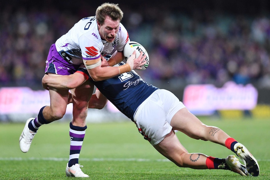 Tim Glasby is tackled by Dylan Napa in the Storm vs Roosters match at Adelaide Oval.