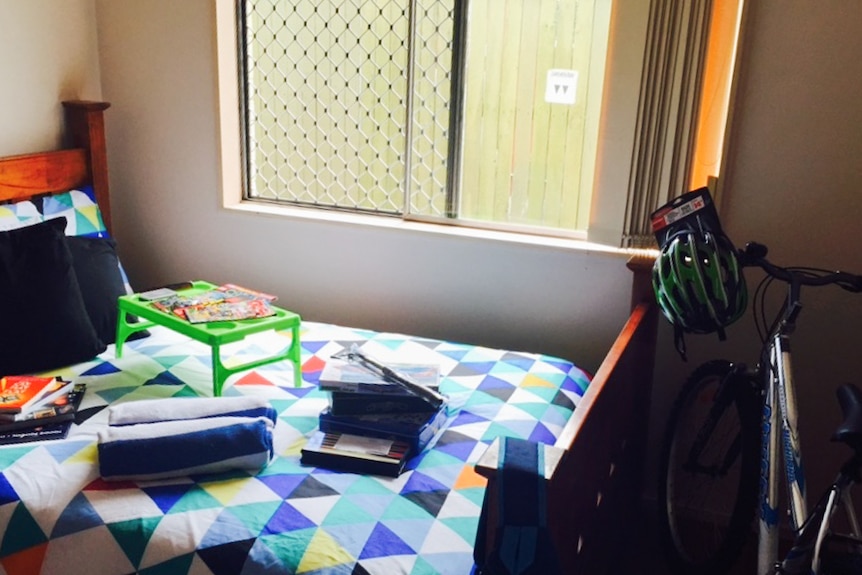 A young boy's bedroom set up by the RizeUp team equipped with bedding, books, toys and a new bike.