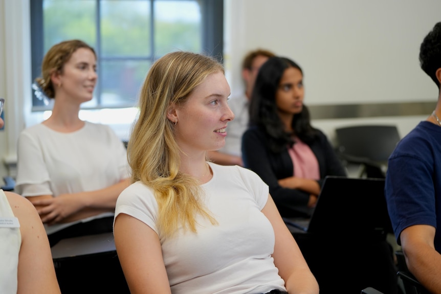 A white woman with blonde hair at the UNSW rural medical school in wagga listening to a presentation. 