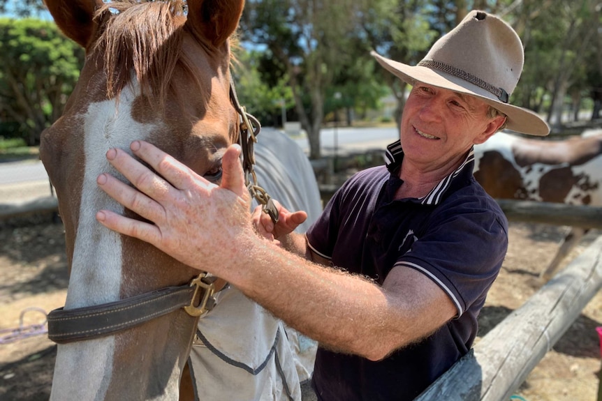 Robert Trigg patting his horse.