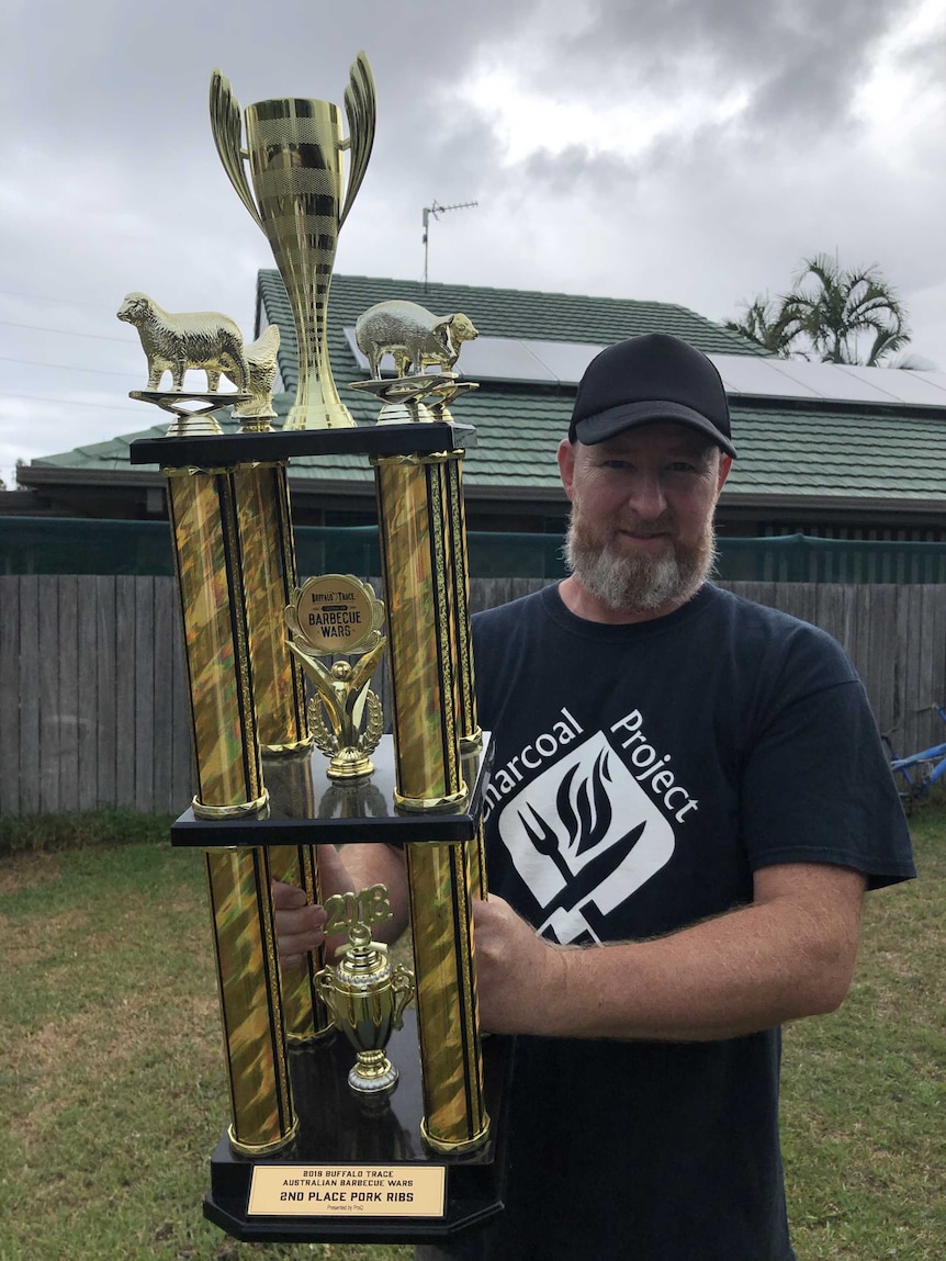 A man holding a giant trophy