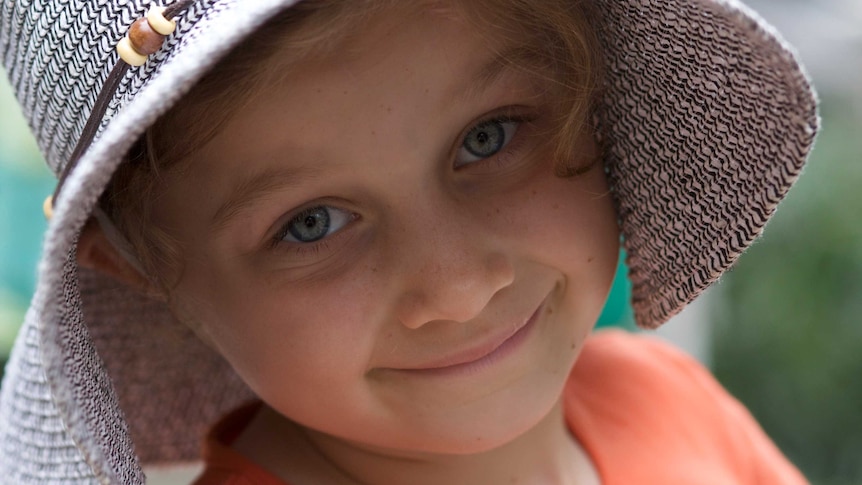 A portrait of a little girl wearing a wide brim hat