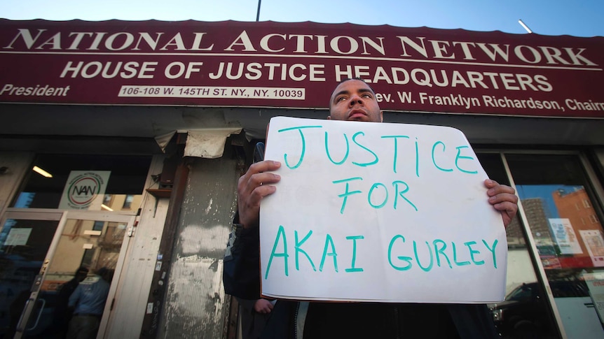 A protester holds a poster outside the National Action Network as reverend Al Sharpton speaks about the death of Akai Gurley, in the Harlem borough of New York November 22, 2014.