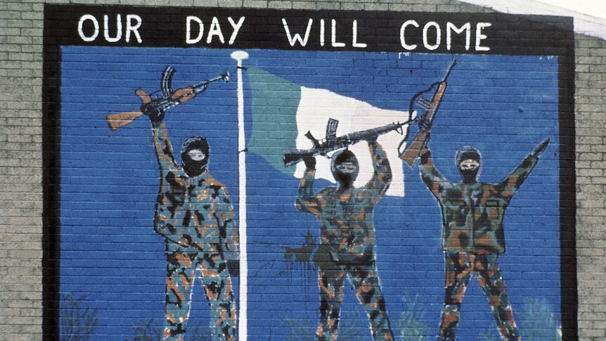 a painting of IRA militants holding rifles with the words "Our Day Will Come" above them