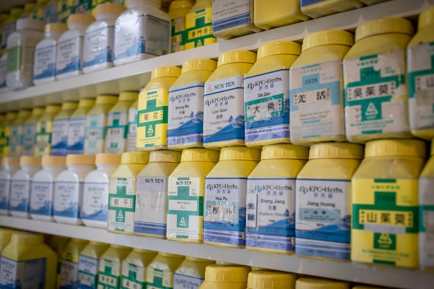 Long rows of bright yellow containers stacked on a shelf in Maria Zong's office.