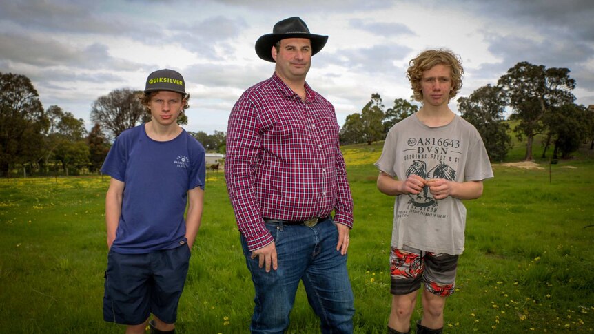 Ron D'Arcy (centre) with his two sons on their property in Toongabbie.