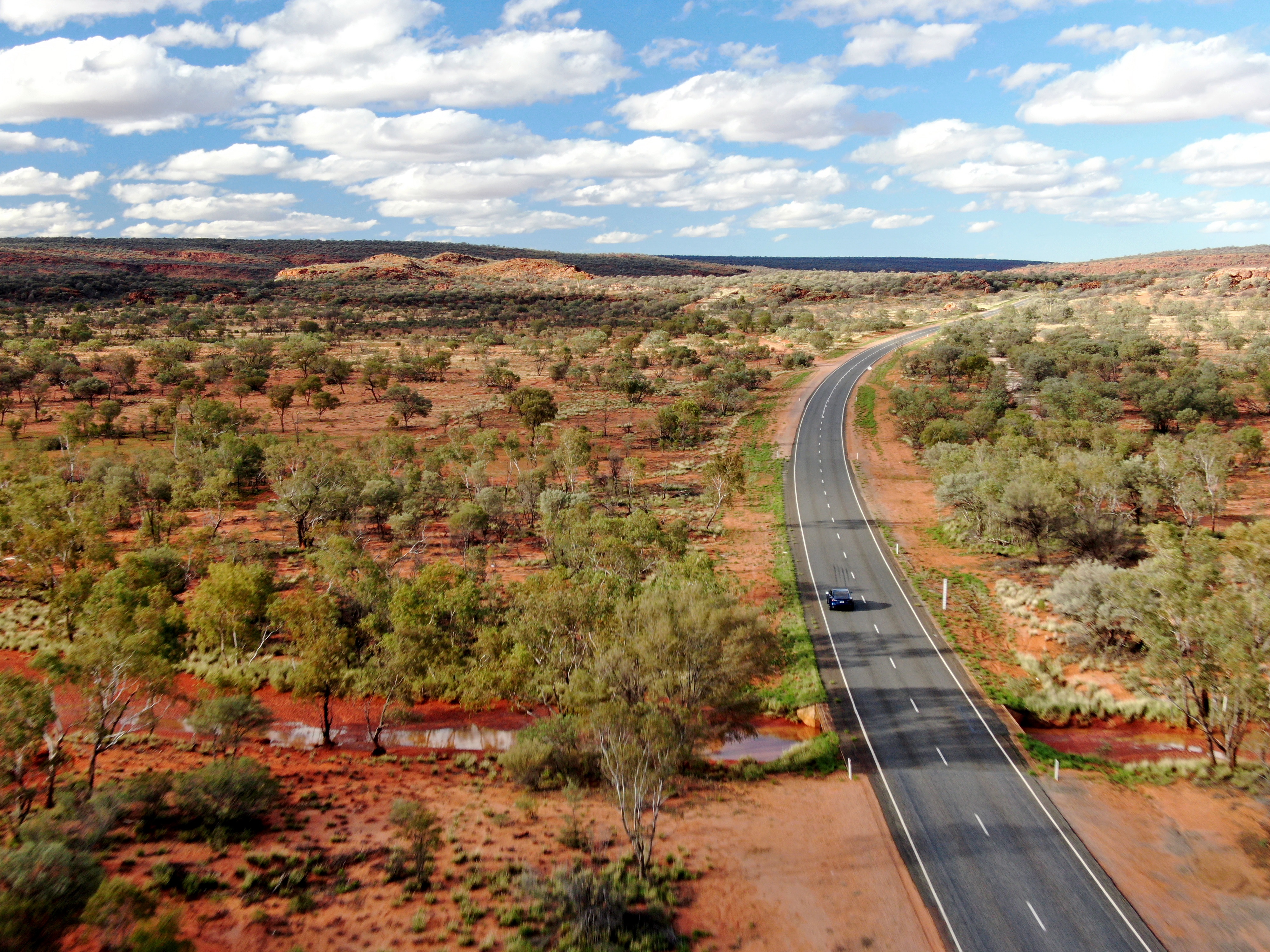 An electric vehicle drives on a remote road.