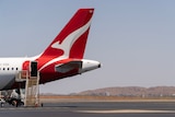 The tailfin of a Qantas plane on the tarmac in outback Australia.