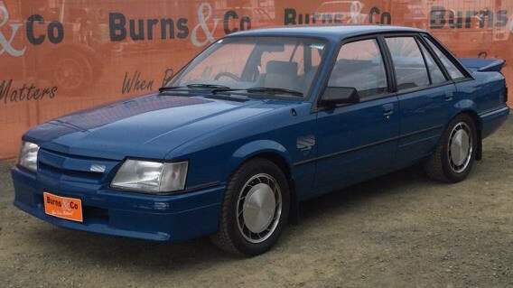 A 1985 VK HDT Commodore Group A Brock Edition SS in dark blue.