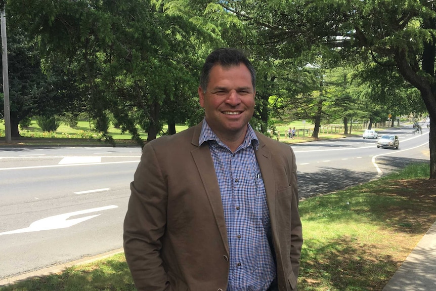 Philip Donato standing in front of trees.