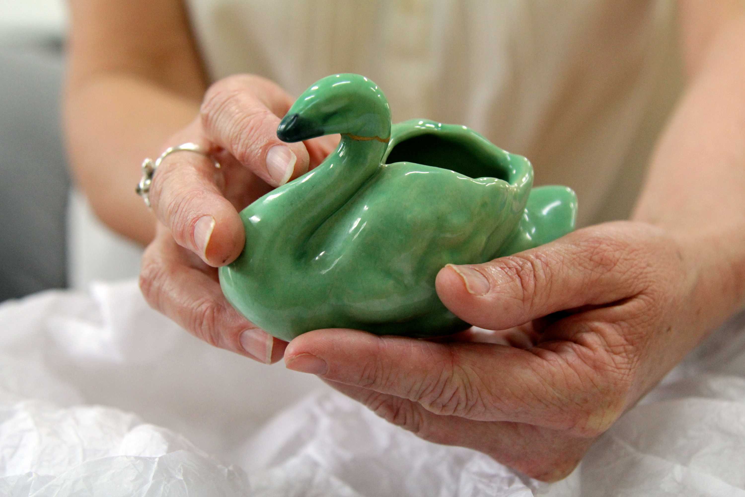 Close up of the porcelain swan in Claire's hands