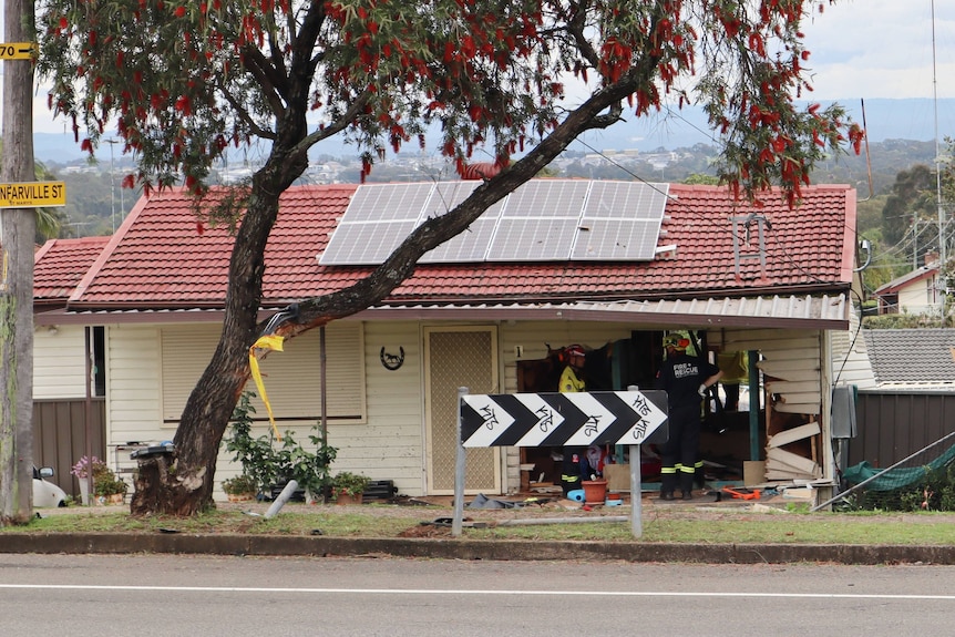 A house with a big hole on the right side of the front when a car crashed into it