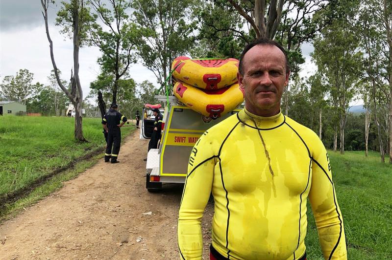 QFES swift water rescue officer Brenden Riches stands behind a vehicle.