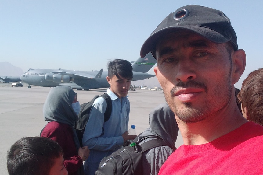 A family gathered among crowds at Kabul airport to flee the Taliban.