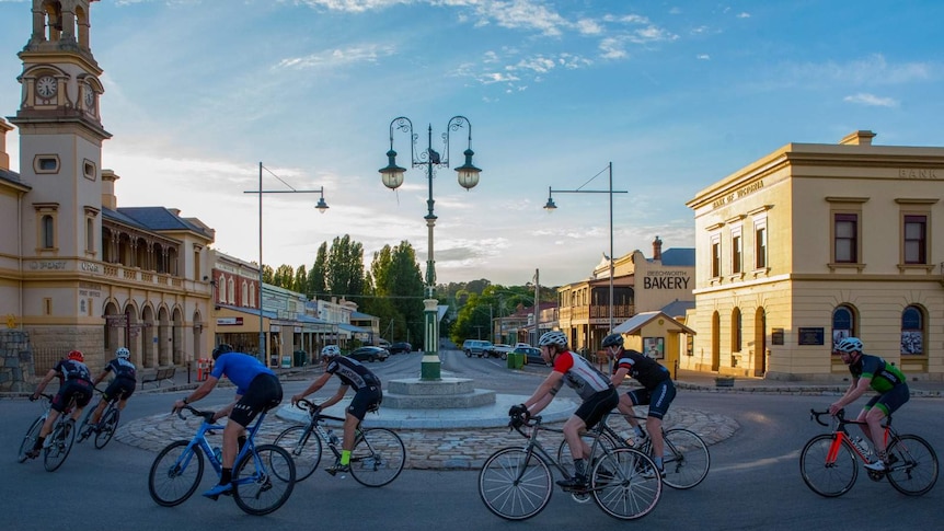 A picture of cyclists navigating a roundabout in an old fashioned Australian street.