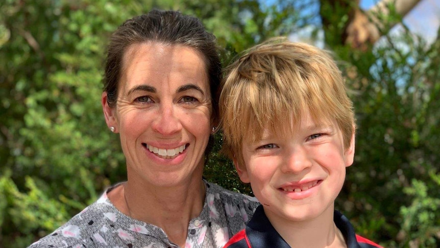 A woman and young boy smile at the camera