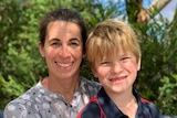 A woman and young boy smile at the camera