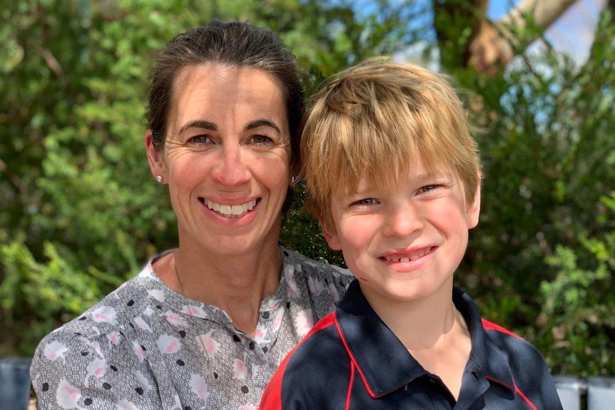 A woman and young boy smile at the camera