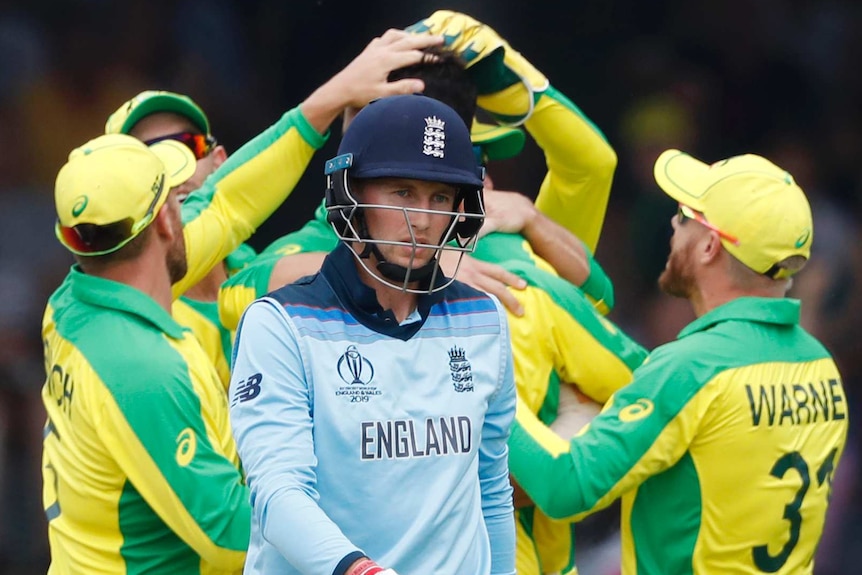 England batsman Joe Root walks past celebrating Australians during their Cricket World Cup match at Lord's.