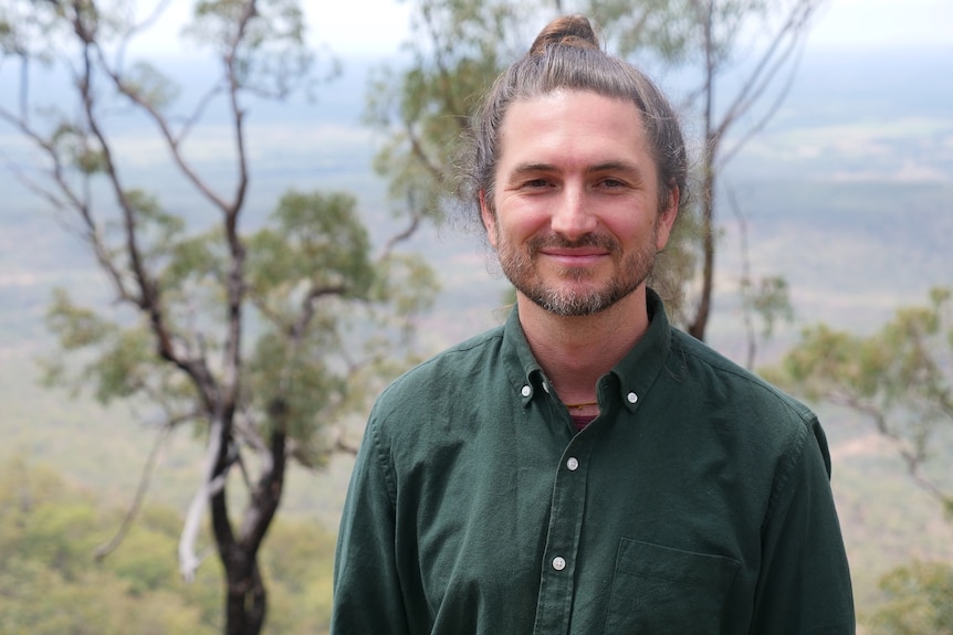 Paul Stephenson smiles at the camera from a lookout at Blackdown Tablelands National Park