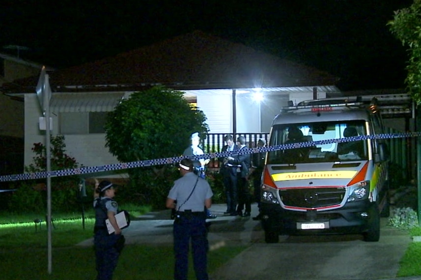 A home taped off with police tape and an ambulance parked in the driveway