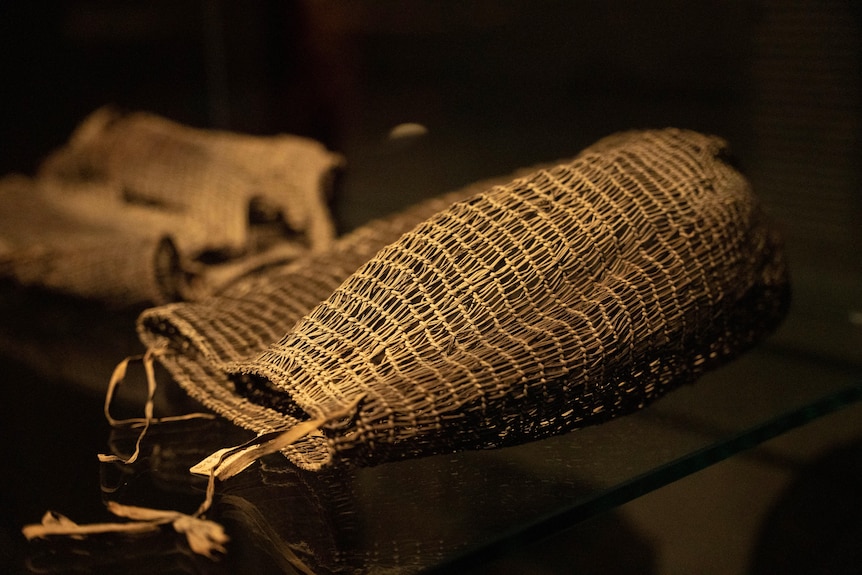 Two woven baskets sit on a black surface.