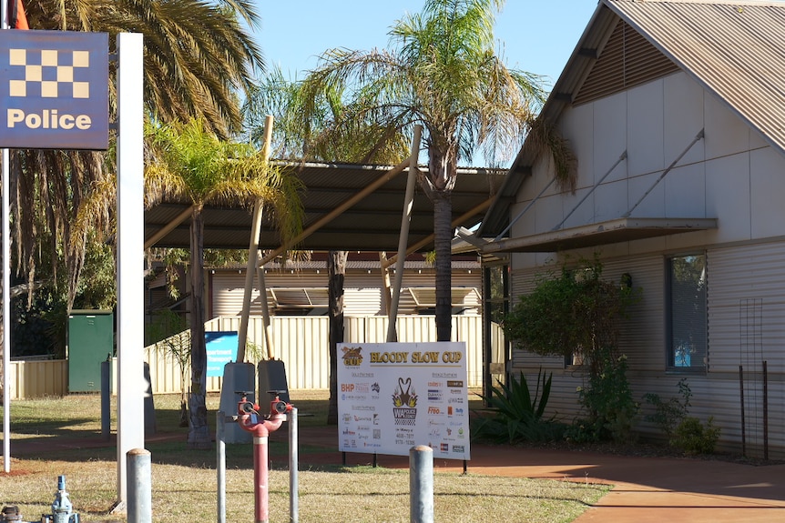 A building with a police sign and trees out the front