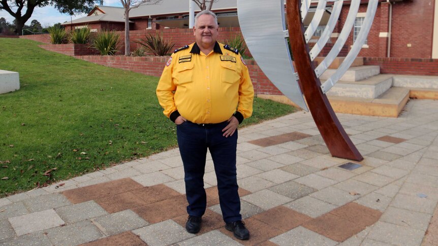 Dave Gossage wearing his uniform stands in front of a sculpture.