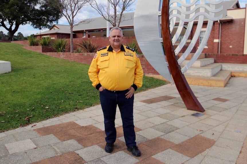 Dave Gossage wearing his uniform stands in front of a sculpture.